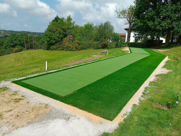 Austin Outdoor tee line consisting of one continuous green synthetic grass strip surrounded by trees